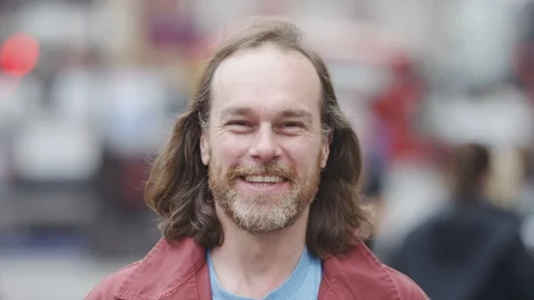 Bearded man in the city looking to camera and smiling Stock Footage 92496176