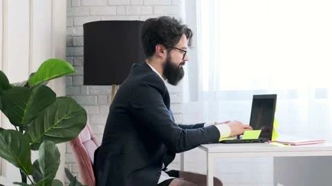 Bearded man comfortable at his desk, in underwear and jacket working remote. Stock Footage 152647792