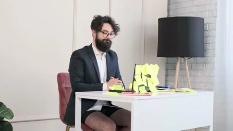 Bearded man comfortable at his desk, in underwear and jacket working remote. Stock Footage 153103752