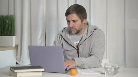 A bearded man is concentrating working at a computer at home at a remote job Stock Footage 167949073