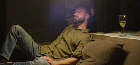 Bearded man on couch thinking, evening Stock Footage 201143235
