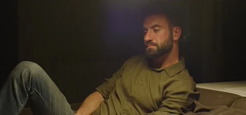 Bearded man on couch thinking, evening Stock Footage 201143247