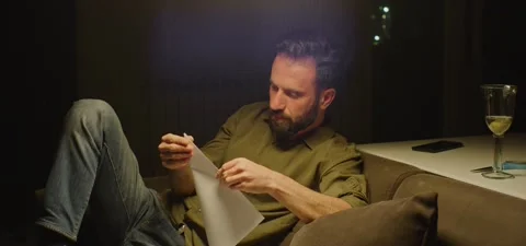 Bearded man on couch thinking, evening Stock Footage 201143248
