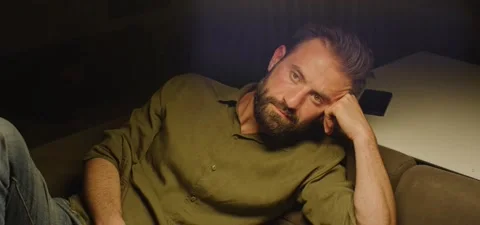 Bearded man on couch thinking, evening Stock Footage 201143777