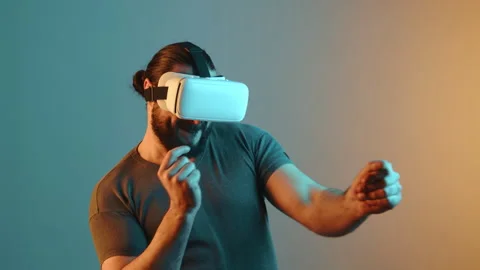 Bearded Man Dancing Joyfully in VR Headset, Grey and Blue Background Stock Footage 267375535