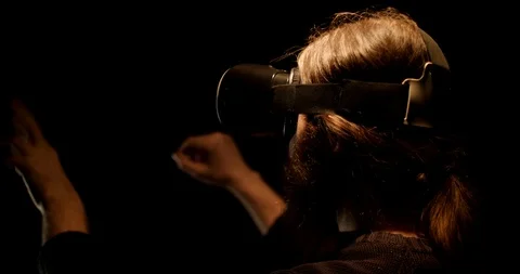 Bearded man in the dark works in virtual reality glasses Stock Footage 88057576