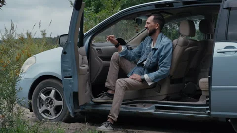 Bearded Man in Denim Jacket Smoking in Minivan Stock Footage 328558220