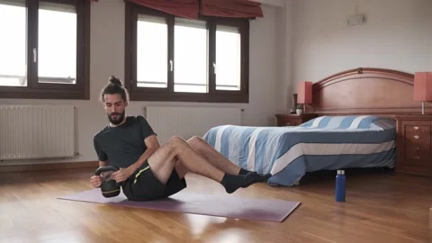 Bearded man doing kettlebell russian twist at home. Daily exercise. Stock Footage 158487851