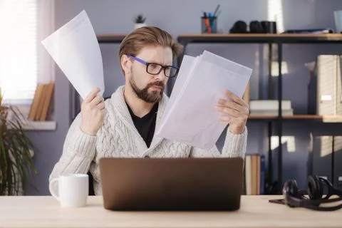 Bearded man doing paperwork while staying at home Stock Photos