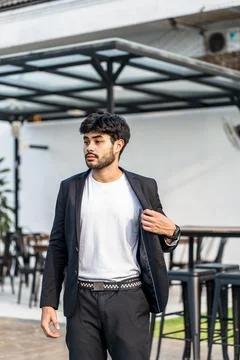 A bearded man doing a pose wearing white shirt with suit as the outer on th.. Stock Photos
