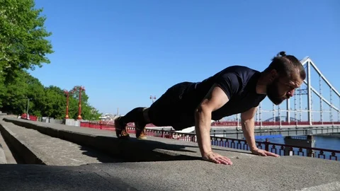 The bearded man is doing push up exercises. Outdoor fitness training. Stock Footage 89716223