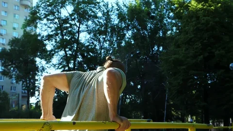 Bearded man doing push-ups on parallel bars at outdoor gym workout. Stock Footage 90371700