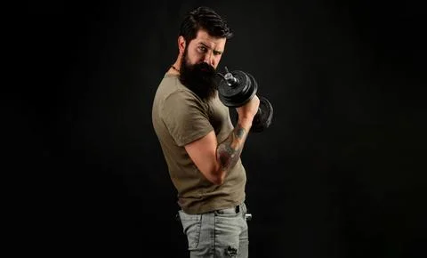 Bearded man doing workout with dumbbell. Handsome muscular man lifting dumbbe Stock Photos