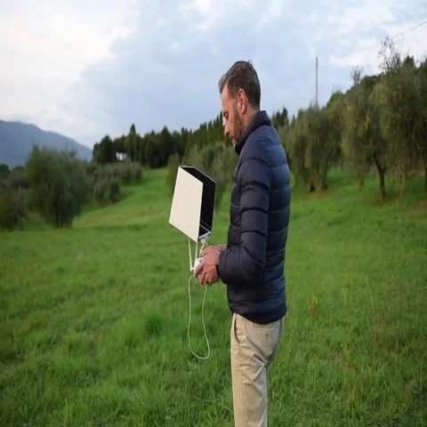 A bearded man dressed in the down jacket watching his tablet and smiling  Stock Footage 69409799