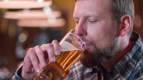 Bearded man drinking beer and enjoying beverage at pub bar HD slow-motion video Stock Footage 71154915