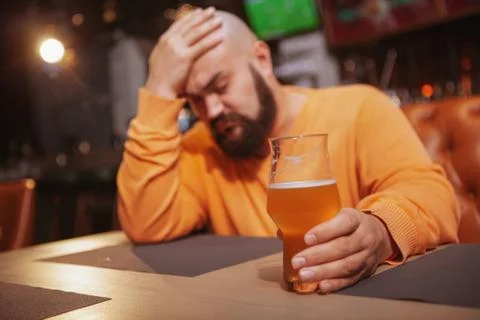 Bearded man drinking beer at the pub Stock Photos