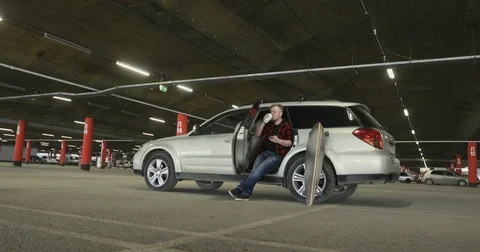 Bearded man drinking coffee and Uses the phone in the car Stock Footage 74972311