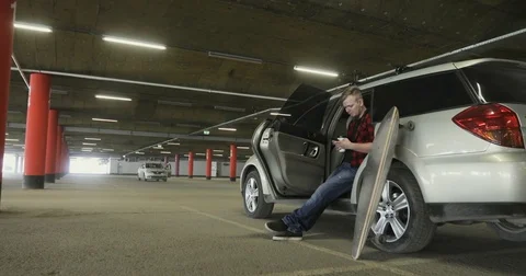 Bearded man drinking coffee and Uses the phone in the car Stock Footage 74973739