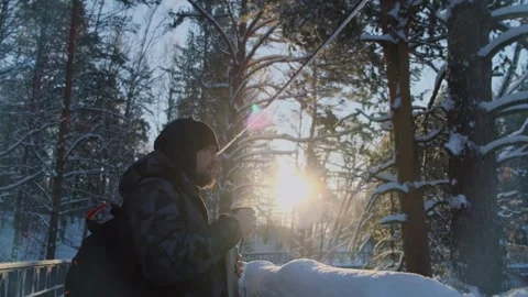 Bearded man drinking hot beverage from thermos in the snowy wood. Stock Footage 259853368