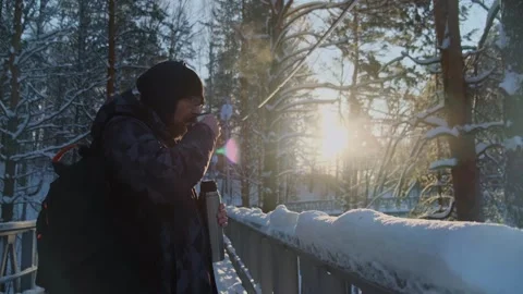 Bearded man drinking hot beverage from thermos in the snowy wood. Video stock 260207152