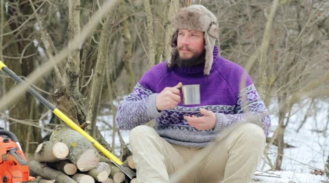 Bearded man drinking tea in the forest. Bearded woodcutter at rest in winter. Stock Footage 59609717