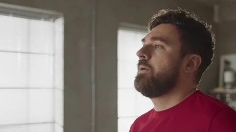 Bearded man drinking water while resting after home exercise routine Stock Footage 169016705