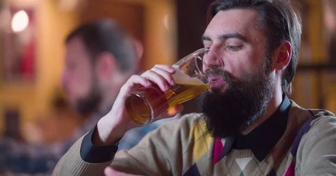 Bearded man drinks beer at pub bar counter 4k close-up video. Taste enjoy lager Stock Footage 71151912