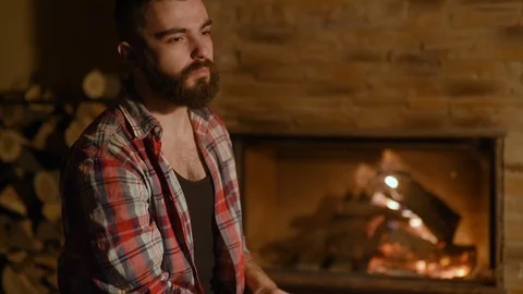 Bearded man drinks tea with an iron mug on a background of a wooden house 動画素材 72465469