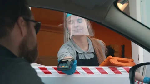 Bearded man driver in car paying with credit card for fast food order at drive Stock Footage 143556135
