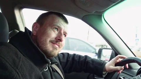 Bearded man driver smiles in the car Stock Footage 74713685