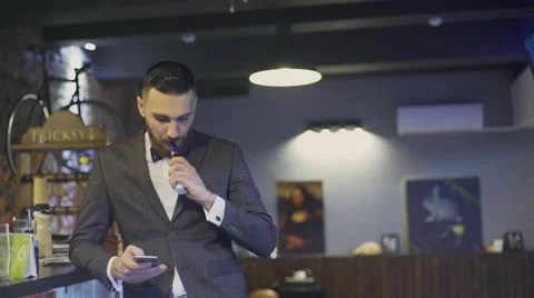 Bearded man with e-cigarette in interior vapes Stock Footage 56576528
