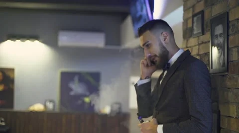 Bearded man with e-cigarette in interior vapes Stock Footage 56576710