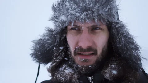A bearded man in earflaps and snow Stock Footage 261853947