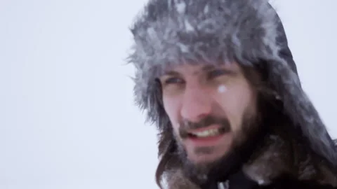 A bearded man in earflaps and snow Stock Footage 261854044