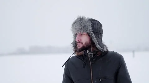 A bearded man in earflaps and snow 動画素材 261854100