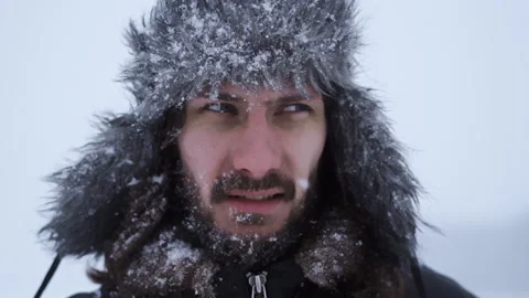 A bearded man in earflaps and snow Stock Footage 261854148