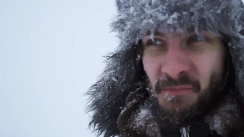 A bearded man in earflaps and snow Stock Footage 261854186