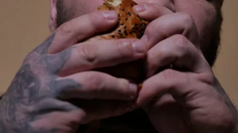 Bearded man eating a hamburger. 4K UHD Vidéo 63400277