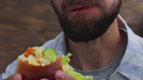 Bearded man  eats  chicken burger with  vegetables close up. healthy food Stock Footage 155893148