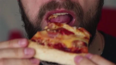 Bearded man eats fast food biting  pizza slice extreme close up Stock Footage 120496593