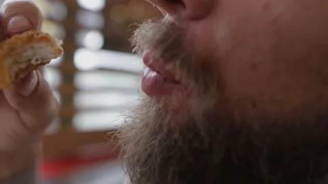 Bearded man eats fried chicken in fast food Vídeo Stock 160544994