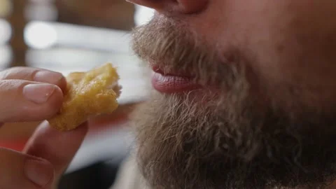 Bearded man eats fried chicken in fast food Видео 160896382