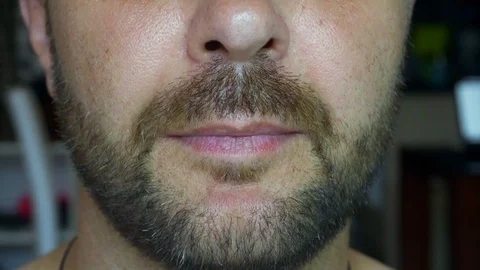 A bearded man eats a juicy watermelon. Extreme close-up of the face. Stock Footage 118371531