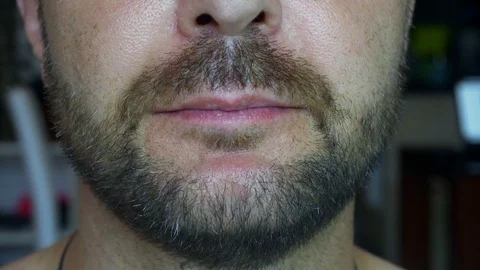 A bearded man eats a juicy watermelon. Extreme close-up of the face. 動画素材 118371704