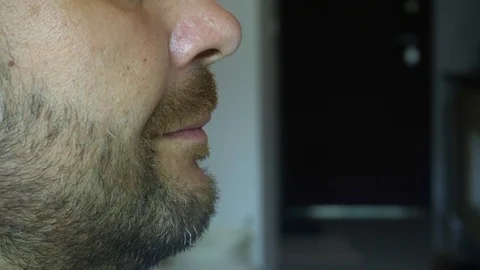 A bearded man eats a juicy watermelon. Extreme close-up of the face. Vídeo Stock 118372003