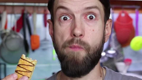 Bearded man eats mini cake close up Stock Footage 158105491