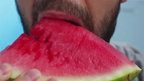 Bearded man eats watermelon extreme close up front view Stock Footage 135380116
