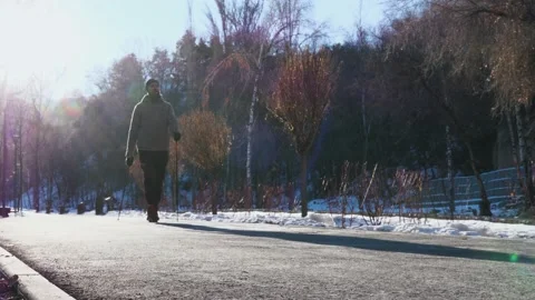 Bearded man is engaged in scandinavian walking in winter park Stock Footage 209824092