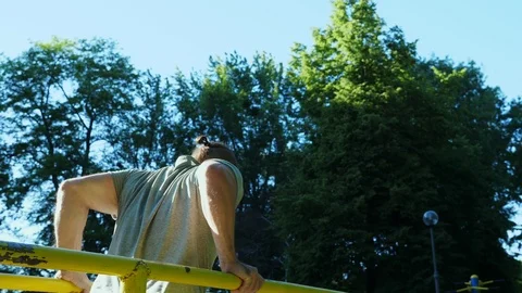 The bearded man exercising arms doing hard exercises on parallel bars. Video stock 90371665
