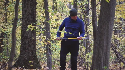 Bearded man in the forest with an ax slowing down. Stock Footage 98601138